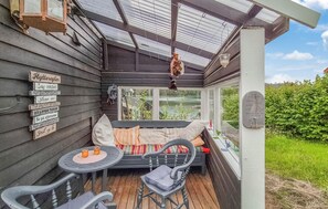 A cozy outdoor seating area with a bench and chairs, a wooden sign with text, and a view of greenery. - Gorgeous home in Førde i Hordaland with WiFi (Førde i Hordaland)