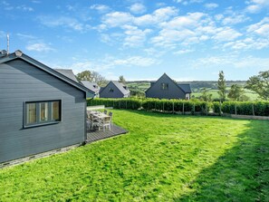 A residential area with a house featuring a deck and a well-maintained lawn. - Fair Isle Holiday Cottages - Fisher (Near Newport)