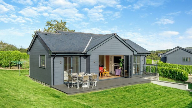 A modern house with a patio, a dining area, and a conservatory. - Fair Isle Holiday Cottages - Fisher (Near Newport)
