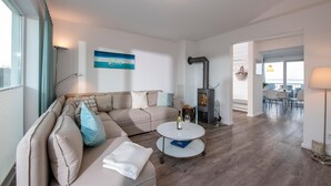 Ein modernes Wohnzimmer mit einer Couch, einem runden Couchtisch und einem Kamin.