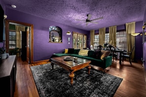 A living room with a green sofa, wooden coffee table, and a ceiling fan.