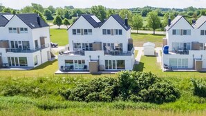 A residential complex with multiple two-story houses featuring balconies, large windows, and a flat roof. - Lovely apartment in Olpenitz with sauna (Olpenitz)