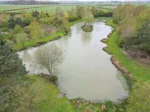 A river meandering through a park with trees and grassy banks.