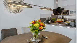 Een moderne keuken met een centraal eiland, roestvrijstalen apparatuur en een decoratief wandobject.