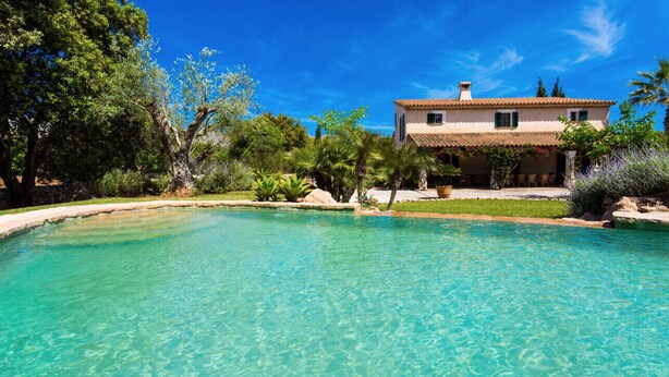 A clear pool with a house in the background. - VILLA CAN TEULADA (Puerto Pollensa)