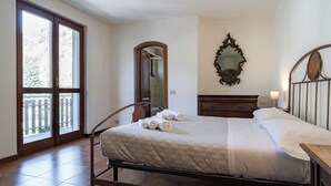 A bedroom with a bed, a dresser, a mirror, and a window. - La grande Valsassina - Salone (Pasturo)