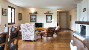A living room with a sofa, chairs, a television, and a fireplace. - La grande Valsassina - Salone (Pasturo)