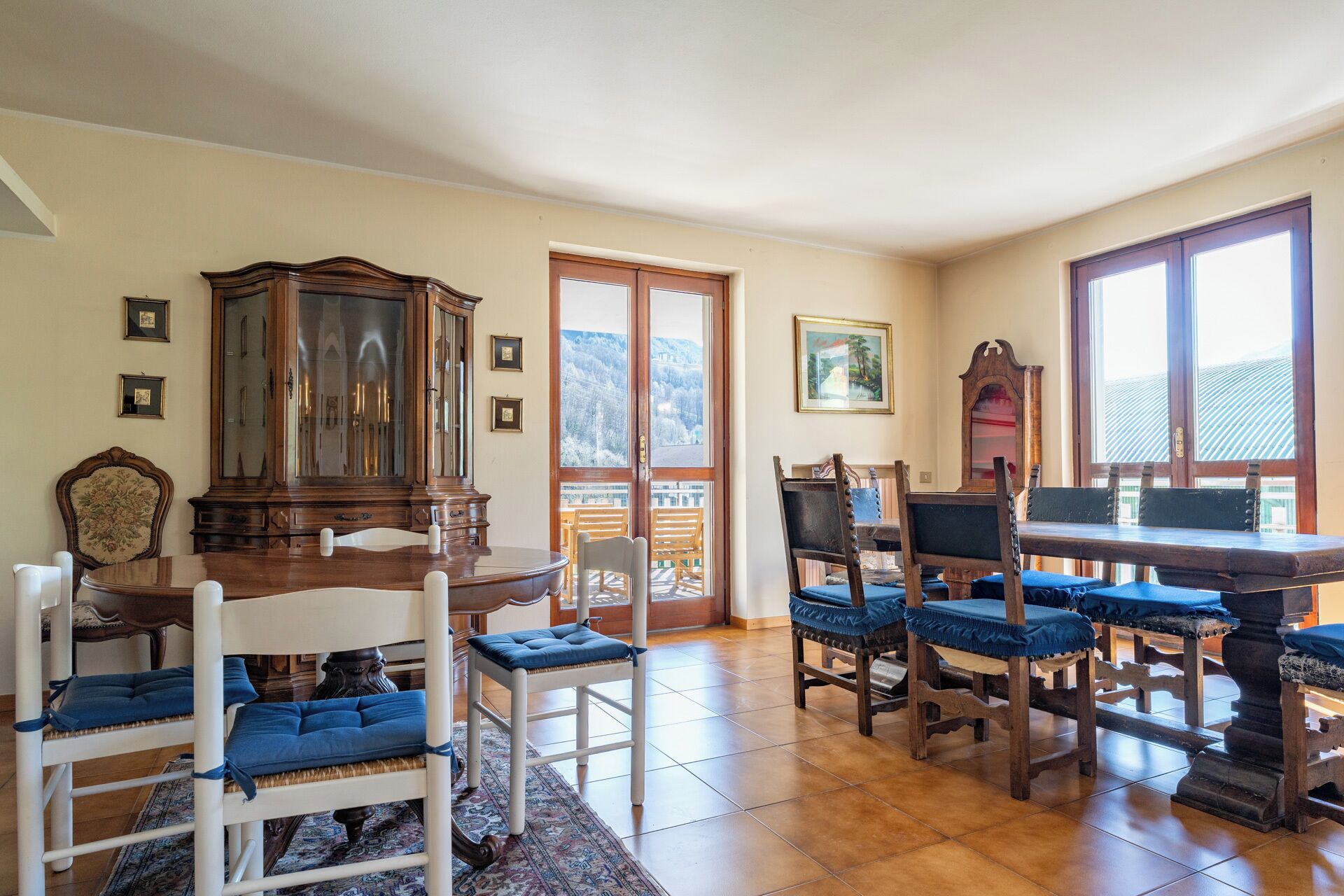 Een eetruimte met een houten tafel, stoelen en een grote kast.