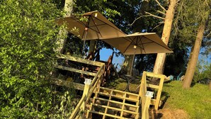 A wooden staircase with a wooden railing and a bench at the top.