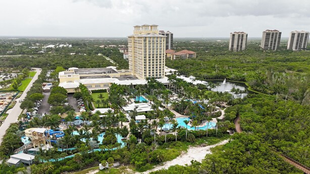 Un complexe hôtelier doté de plusieurs piscines, d’un grand bâtiment et entouré de verdure.