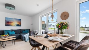 Un salon moderne comprenant un coin repas, un canapé, une table basse et une vue sur l’extérieur.