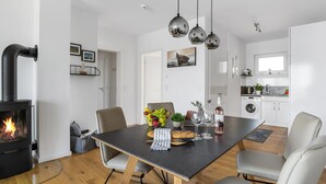 A modern kitchen with a central island, a built-in stove, and pendant lighting.