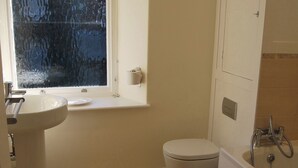 A bathroom with a toilet, sink, and window. - A charming, contemporary Lakeland cottage in the very heart of Ambleside. (Ambleside)