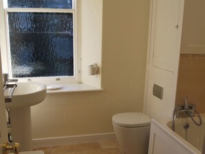 A bathroom with a toilet, sink, and window. - A charming, contemporary Lakeland cottage in the very heart of Ambleside. (Ambleside)