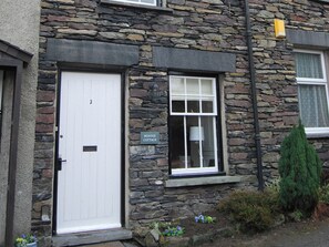A stone building with a white door and a window. There is a sign that reads 'BONNIE COTTAGE.' - A charming, contemporary Lakeland cottage in the very heart of Ambleside. (Ambleside)