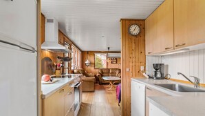 Une cuisine de taille réduite, avec des meubles de rangement en bois, un évier et une machine à café.