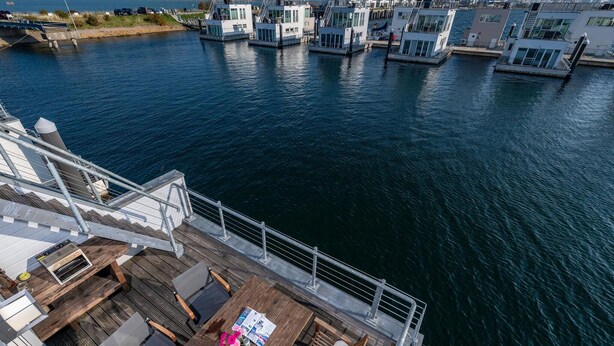 Eine Terrasse mit Sitzgelegenheiten und Blick auf das Wasser.