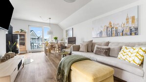 Een moderne woonkamer met een bank, een salontafel en een eethoek met stoelen en een tafel.