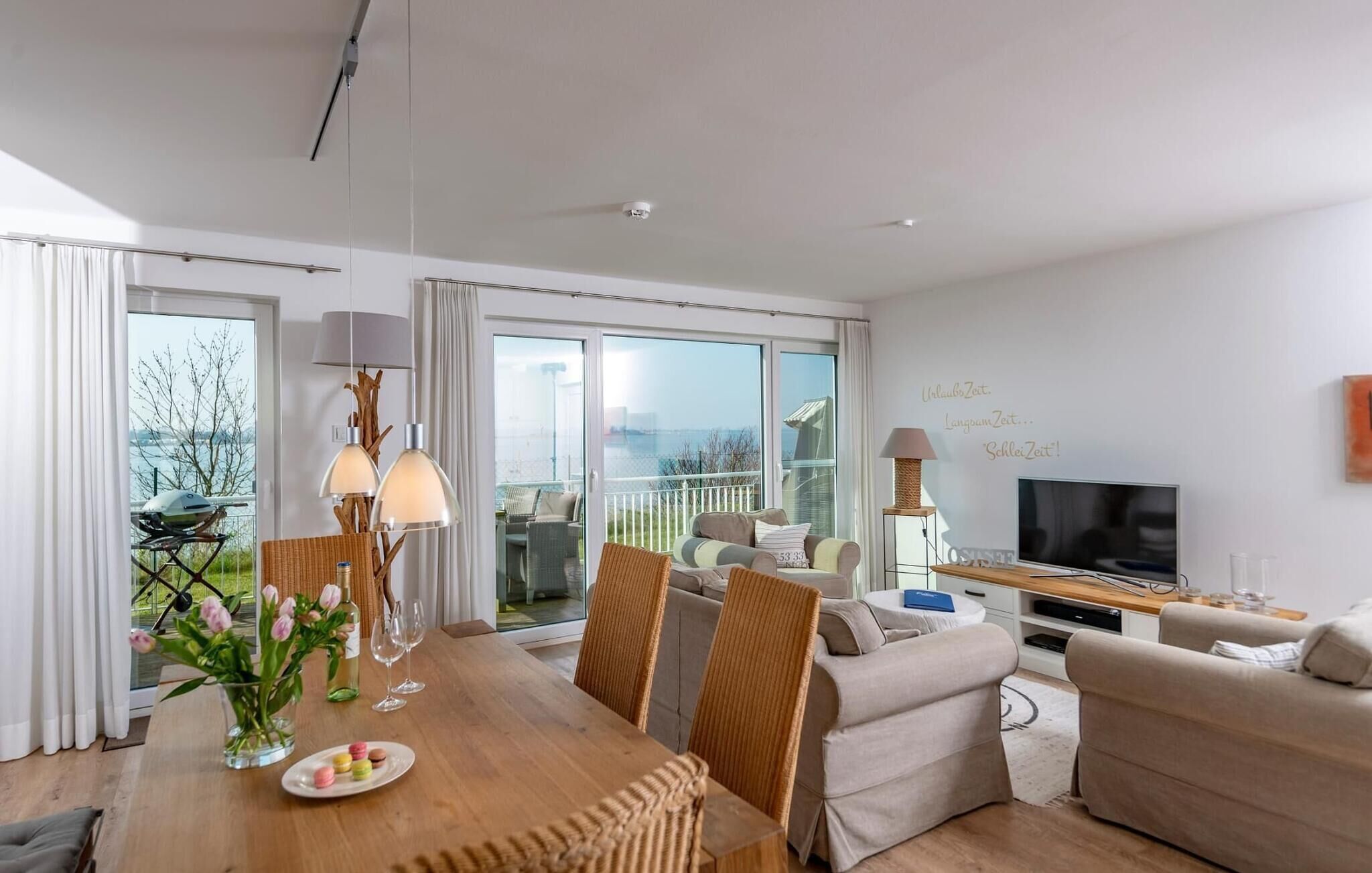 Un salon moderne comprenant un coin repas, un canapé, un téléviseur et un balcon avec vue.