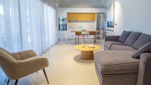 Una sala moderna con sofá, sillón y una mesa de centro redonda.