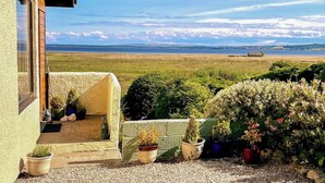 Una casa con vista a una amplia extensión de agua y una costa distante.