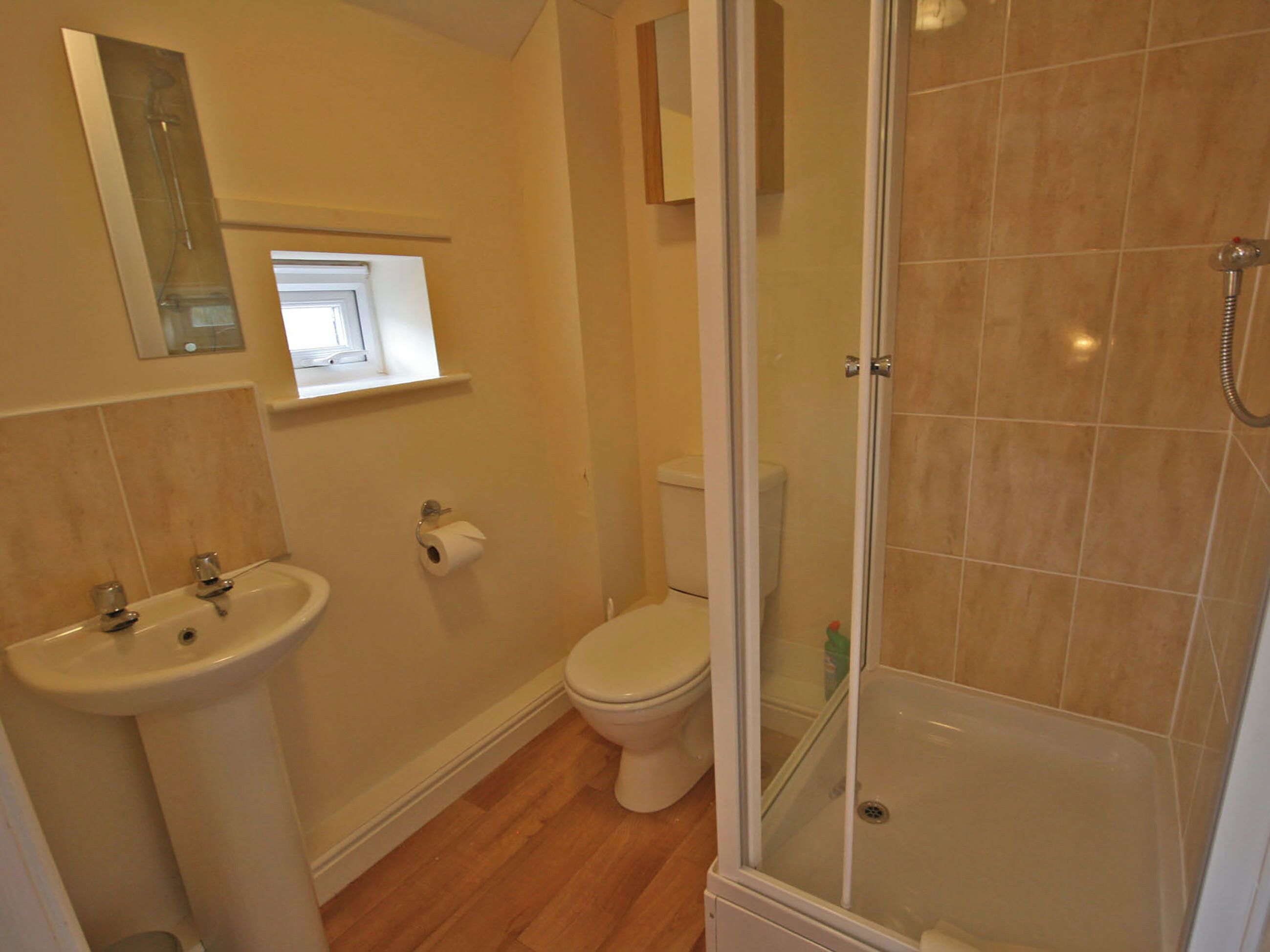 A bathroom with a sink, toilet, and glass-enclosed shower.