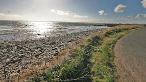 A coastal road with a rocky beach and a clear sky. - 2 bedroom accommodation in North Keiss, Caithness (North Keiss, Caithness)
