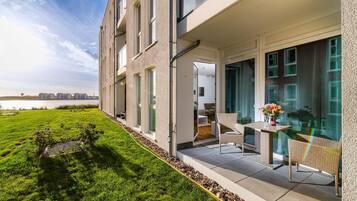 Eine moderne Wohnung mit Balkon, großen Fenstern und Blick auf das Wasser.