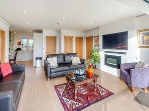 A modern living room with a sofa, coffee table, and a flat-screen TV.