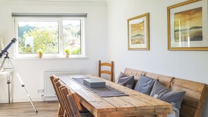 A dining area with a wooden table, benches, and a tripod. - 5 bedroom accommodation in Brodick, Isle of Arran (Brodick, Isle of Arran)