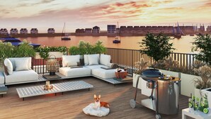 A rooftop terrace with a sofa, a dog, a grill, and a view of boats on the water. - Pet friendly apartment in Olpenitz (Olpenitz)