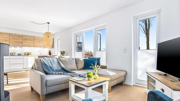 A modern apartment with a living room, kitchen, and dining area.