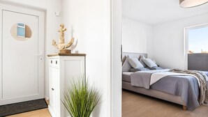 A modern bedroom with a bed, bedside tables, and a window.