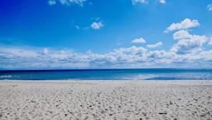Ein Strand mit klarem Himmel und ruhiger See.