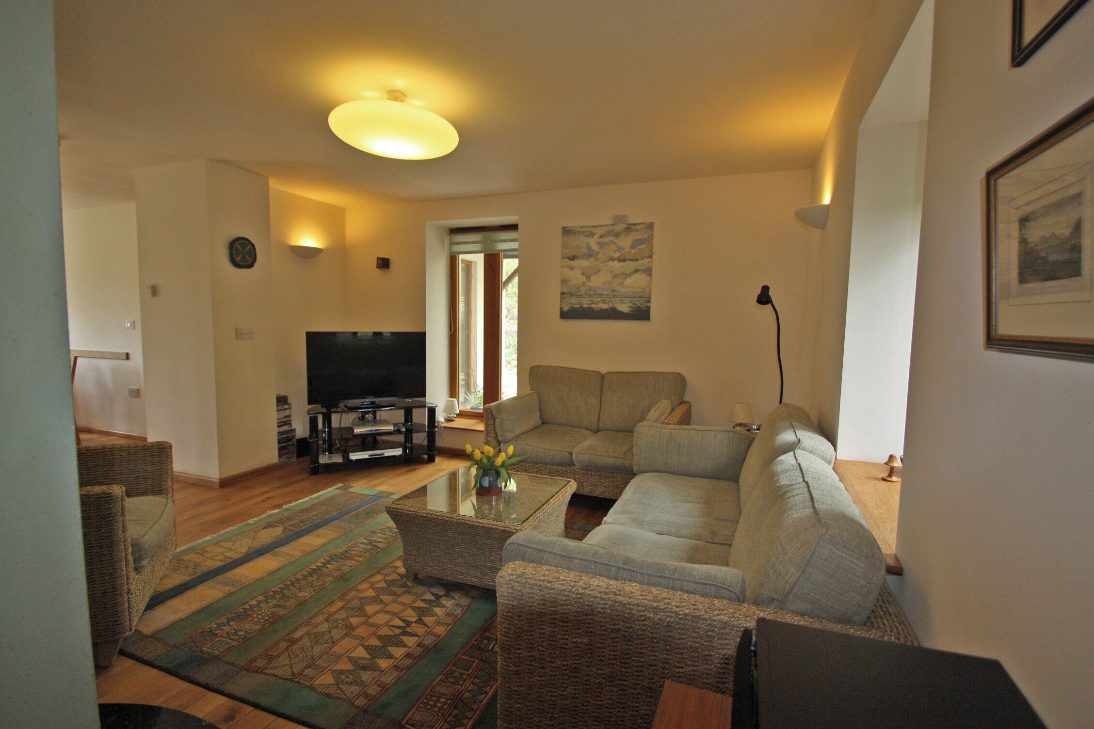 A living room with a sofa, coffee table, and television.