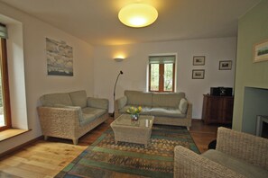 A living room with two sofas, a coffee table, and a fireplace.