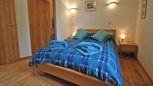 A bedroom with a wooden bed, two bedside lamps, a wooden wardrobe, and a framed picture on the wall. - 4 bedroom accommodation in Cilycwm, Llandovery (Cilycwm, Llandovery)