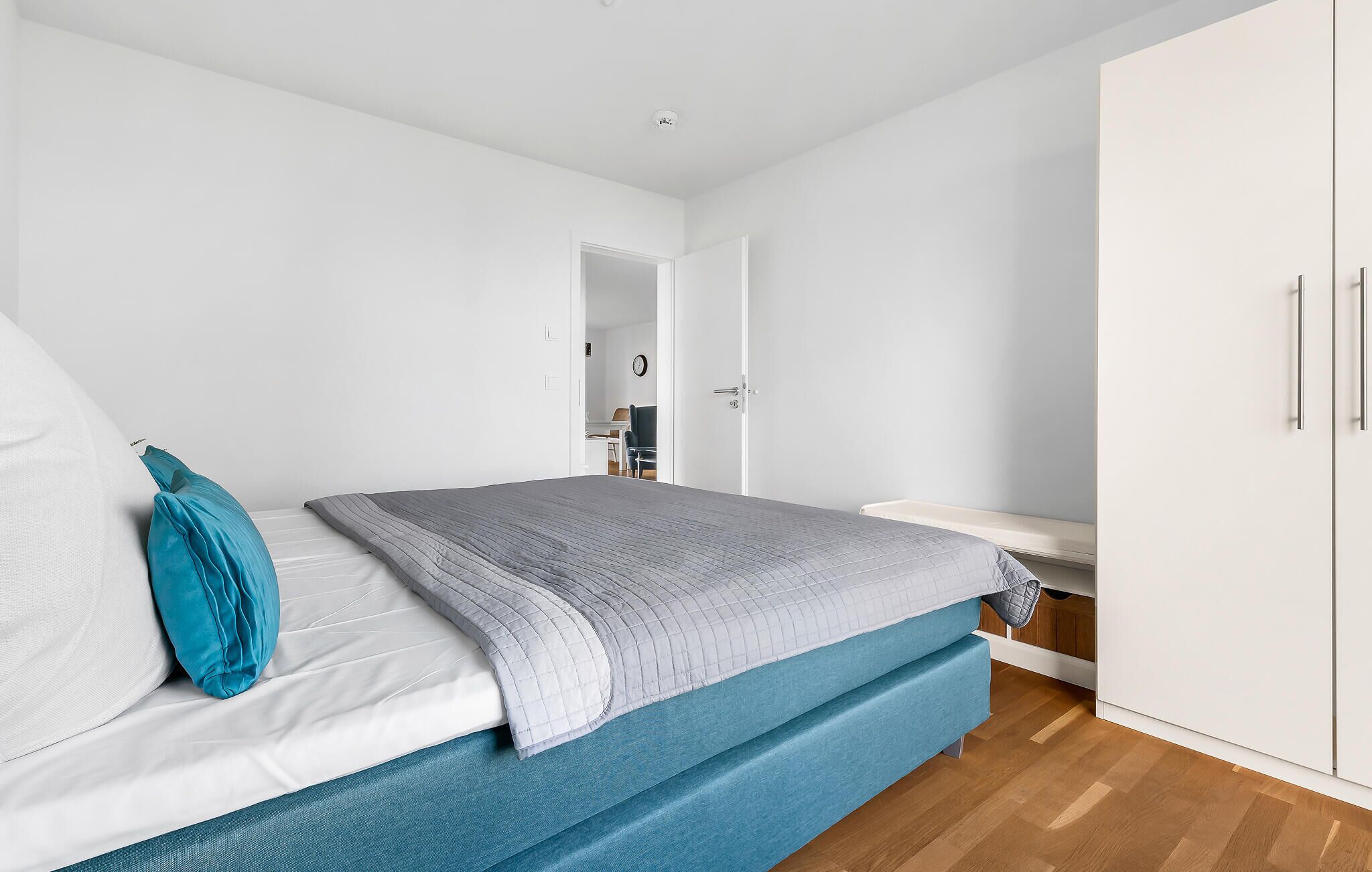 A bedroom with a bed, a wardrobe, and a desk.