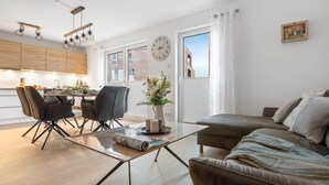 Un salon moderne comprenant un canapé, une table basse et un coin repas avec des chaises et une table.