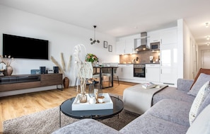 Relax in this stylish living space with a large flat-screen TV, comfortable sofa, and dining area.