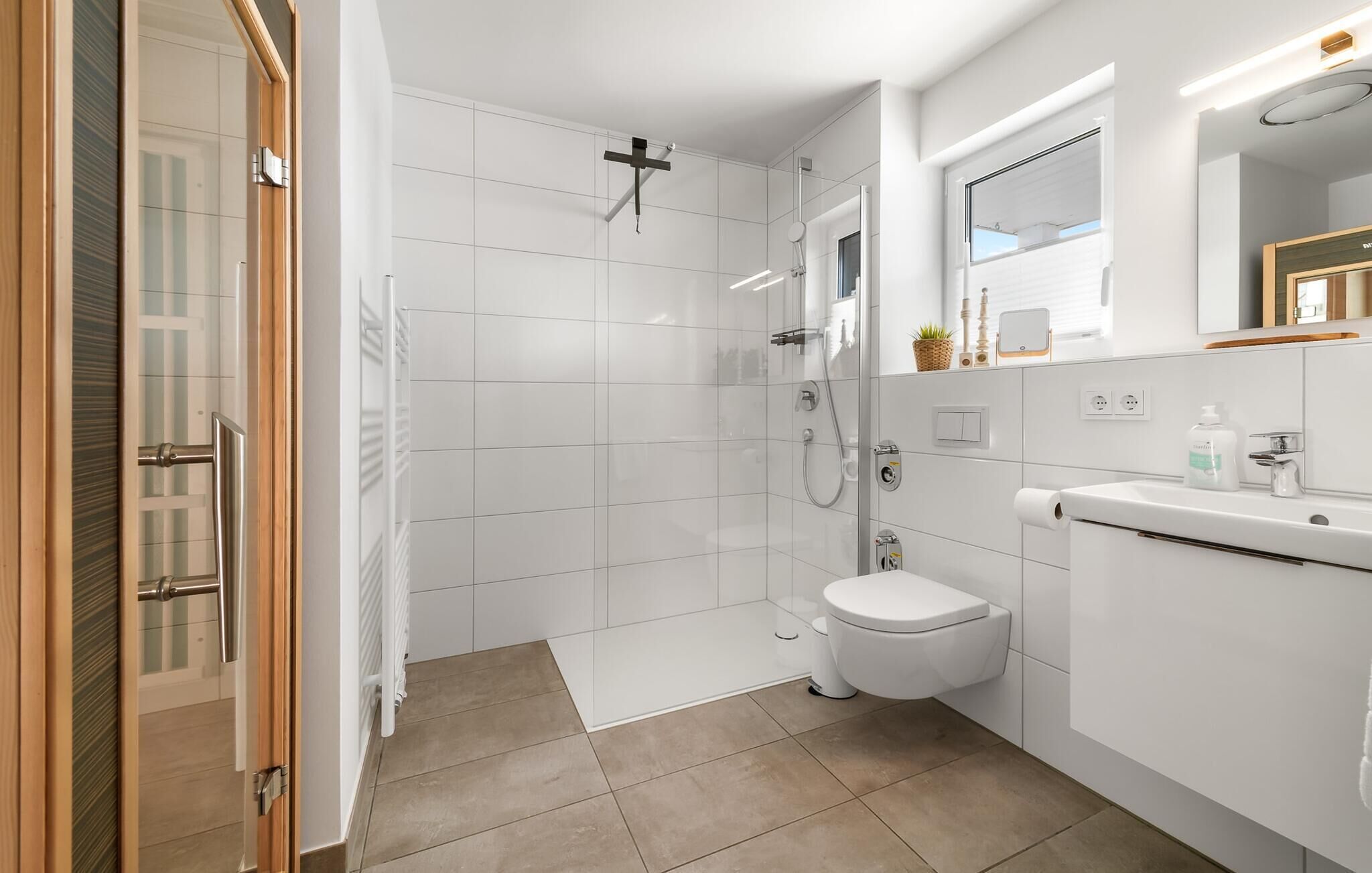 Une salle de bain moderne équipée d’une douche, de toilettes et d’un lavabo.