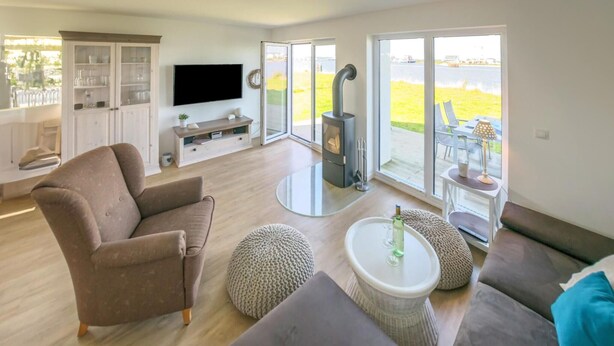 A modern living room with a sofa, ottoman, and a TV.