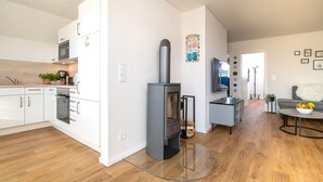 A modern kitchen with white cabinetry, a built-in oven, and a microwave.