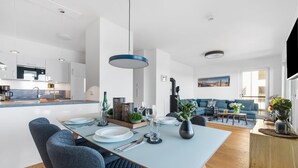 Un espace de vie moderne comprenant un coin repas, une cuisine et un coin salon.