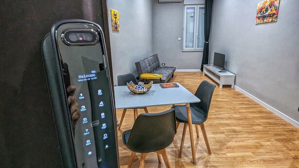 Ein modernes Wohnzimmer mit Essbereich, einer Couch, einem Couchtisch und einem Fernseher.