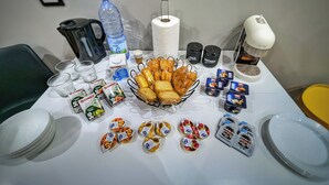 Ein reichhaltiges Frühstücksbuffet mit verschiedenen Speisen, darunter Backwaren, Würzmitteln und Getränke.