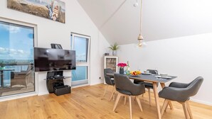 Un salon moderne doté d’un téléviseur à écran plat, d’une table à manger et de chaises.