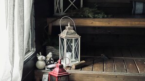 A wooden bench with a lantern and decorative items.