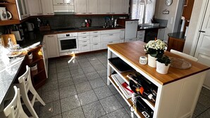 A kitchen with white cabinets, a granite countertop, and a built-in wine rack.