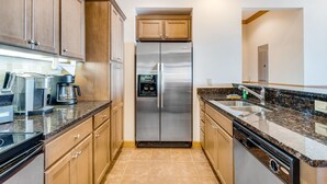 A modern kitchen with stainless steel appliances, wooden cabinets, granite countertops, and a built-in dishwasher. - Comfy Condo At Top Of Sugar Mtn - Ski In Ski Out - AC, WiFi (Sugar Mountain)